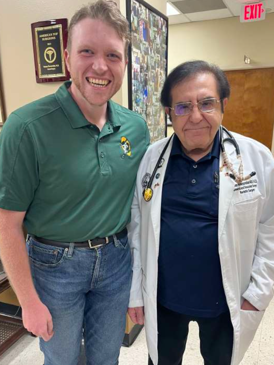 Two men standing together in a room with medical decor